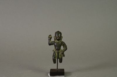 statue représentant un homme tenant un oiseau, posée sur un socle en bois