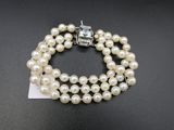 un gros plan d'un bracelet orné de perles sur un fond noir
