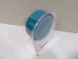 a small blue object in a clear container on a counter