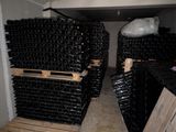 several stacks of wine bottles are stacked on pallets in a room