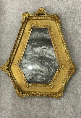 miroir à cadre doré sur fond gris