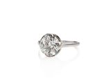 a close up of a diamond ring on a white surface