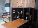 a table and chairs in a room with a wall mounted clock