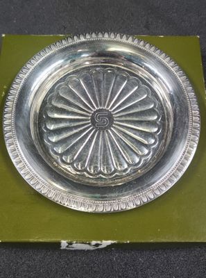 a silver plate with a flower design on it