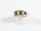 un gros plan d'une bague en or jaune sertie de saphirs et de diamants