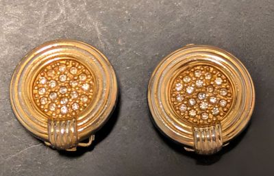 une paire de boucles d'oreilles en or et diamants posées sur une surface noire