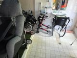 une pièce avec une chaise, un vélo, un lavabo et un miroir