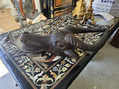 a statue of an elephant laying down on a table