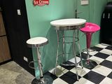 two stools and a table in the corner of a room