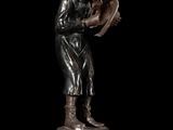 bronze statue of a boy reading a book on a pedestal