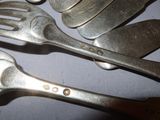 a lot of forks and spoons that are on a table