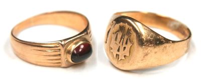pair of gold rings with garnetts on them on a white surface