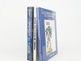two books sitting on top of each other on a white surface