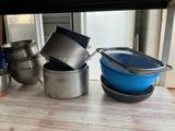 many pots and pans sitting on a wooden table