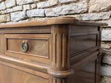 a wooden cabinet with a drawer on it in front of a brick wall