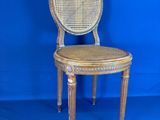 une vieille chaise en bois avec une assise en osier, sur fond bleu