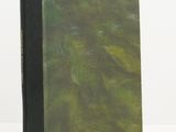 un livre à la couverture verte posé sur une table blanche