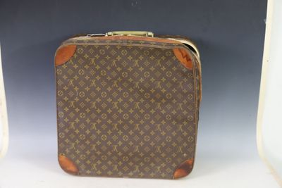 an old louis vuitton suitcase sitting on top of a white table