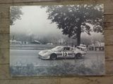 a black and white photo of a race car on the track