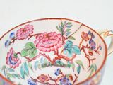 a cup with a floral design on it sitting on a table