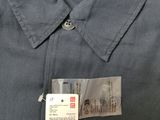 the label is on the shirt of a man who is wearing a dark blue shirt
