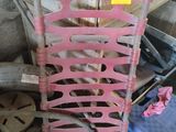 a pink chair that is sitting next to a pile of tools