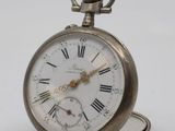 a silver pocket watch with roman numerals on it