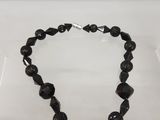 Le collier est en verre noir et possède un fermoir en argent.