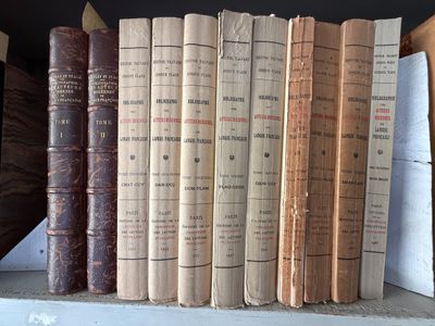 de nombreux livres anciens rangés sur une étagère dans une bibliothèque