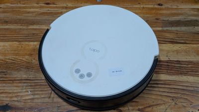 une photo d'un aspirateur robot posé sur une table en bois