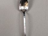 a silver spoon with a black handle on a white surface