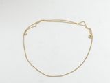 un bracelet à chaîne en or avec une breloque en forme de cœur sur fond blanc