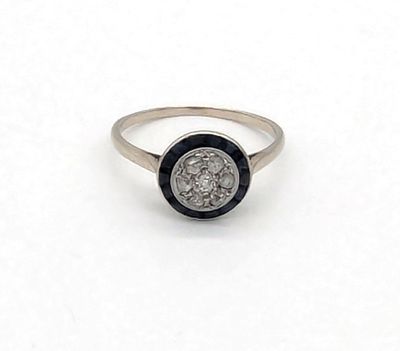 un gros plan d'une bague sertie de diamants sur une surface blanche