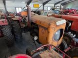 many old tractors in a large warehouse with a lot of them