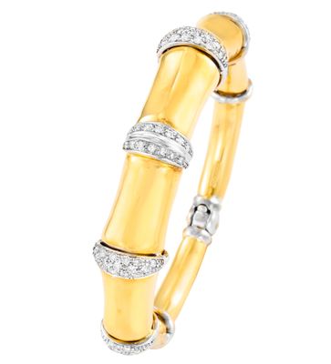 gros plan d'un bracelet en or et diamants sur fond blanc
