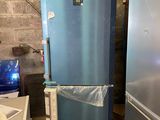 two refrigerators that are sitting in a room