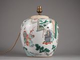 un vase blanc orné d'un motif vert et rouge