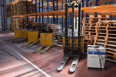 a forklift in a warehouse with pallets and pallets