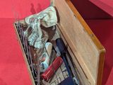 a wooden box filled with assorted items on a red surface