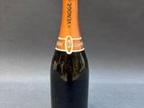 a bottle of orange wine sitting on top of a table