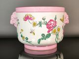 a white bowl with a pink handle and flowers on it