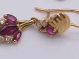 two pairs of earrings and a ring on a white surface