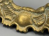 un gros plan d'une broche en or ornée d'un oiseau
