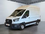 La camionnette blanche est garée dans une grande pièce au sol gris.