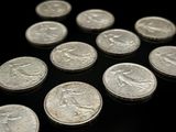 quelques pièces d'argent sont disposées en triangle sur une surface noire