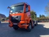 un gros camion orange garé sur un parking