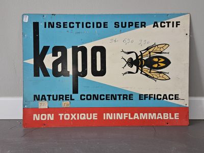 une pancarte sur laquelle est écrit « kapo », posée devant un mur