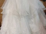 a white dress hanging on a hanger in a room