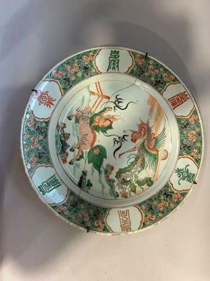 une assiette ornée d'un dragon, posée sur une table