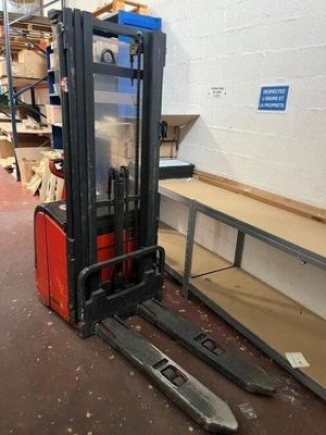 a fork lift truck in a warehouse with boxes on the floor